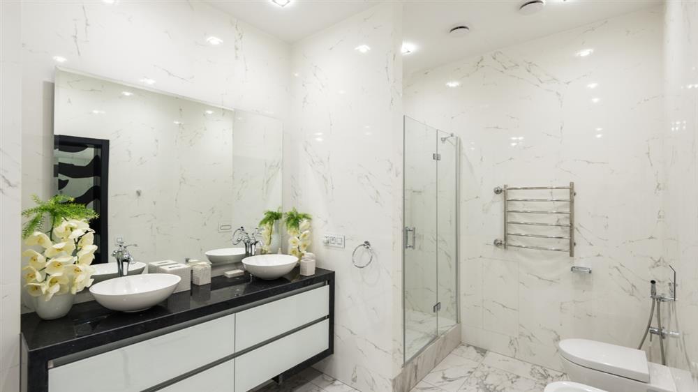 Modern white marble bathroom with double vanity and glass shower